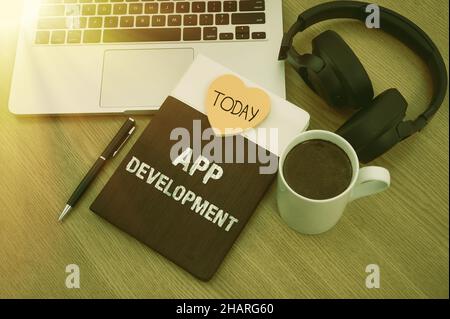 Hand writing sign App Development. Internet Concept Development services for awesome mobile and web experiences Blank Notepad Laptop With Pen And Stock Photo