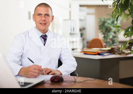 Man doctor working at medical office Stock Photo
