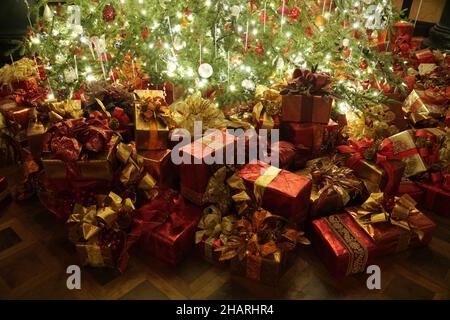 Beautifully wrapped of gifts under the Christmas tree with lights Stock Photo