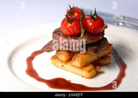 Beef steak with tomatoes and french fries Stock Photo