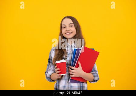 cheerful teen girl in checkered shirt holding coffee cup and notebook, childhood. Stock Photo