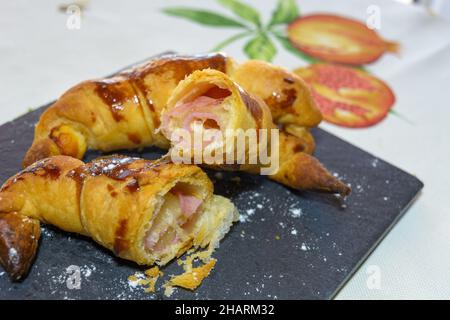 Freshly baked small croissants stuffed with ham and melted cheese Stock Photo