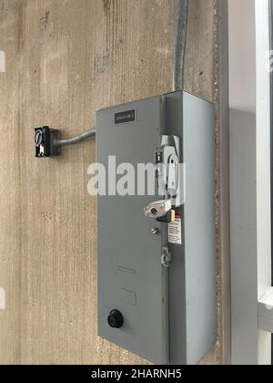 A gray industrial power box on a wall in a building Stock Photo