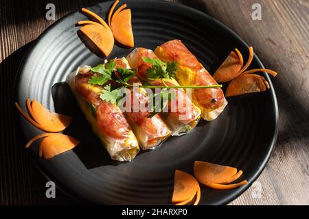 Summer Roll (Goi cuon) is a Vietnamese snack with ingredients including rice paper, cassava roots, shrimp, sausages, fried eggs and vegetables. dipped Stock Photo