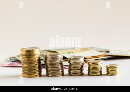 Turkish currency coins stacked,growing on white surface,in front of paper money,selective focus Stock Photo