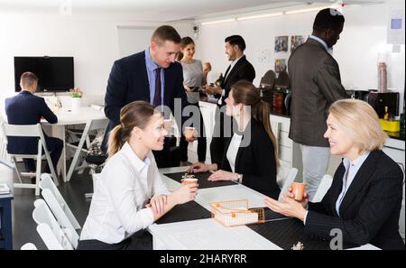 business people chatting while enjoying coffee Stock Photo