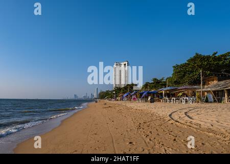 Najomtien beach Pattaya Thailand December 2021, sunset at a tropical beach with palm trees. Pattaya Thailand, people relaxing in front of a restaurant at the beach Stock Photo