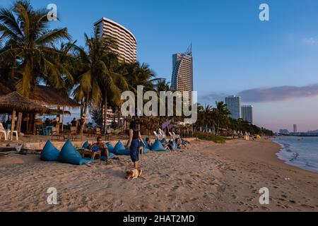 Najomtien beach Pattaya Thailand December 2021, sunset at a tropical beach with palm trees. Pattaya Thailand, people relaxing in front of a restaurant at the beach Stock Photo