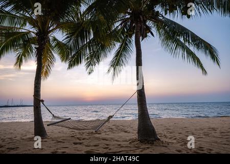 NaJomtien Pattaya Thailand, Hammock on the beach during sunset with palm trees. Na Jomtien Pattaya Stock Photo