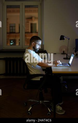 Freelance copywriter or web content editor prepare material for publication on website work at night Stock Photo