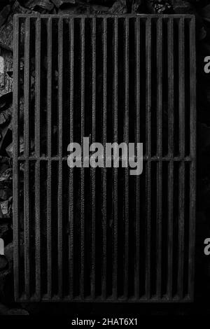 Top view of black cast iron grate over cold coals on grill Stock Photo