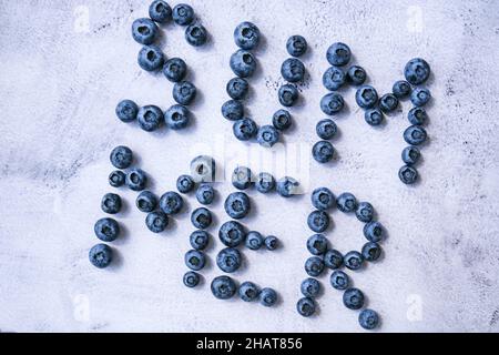 Summer inscription lined from blueberries. Fruits and berries, vegetarian and healthy eating concept. Summer text created from blueberries. Superfood Stock Photo