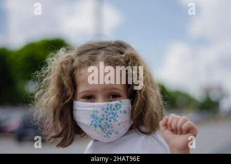 Little sweety girl wear masks to protect against dust and viruses, the epidemic period is happy and hopeful. Selective focus in face. Stock Photo