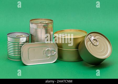 A Group of Stacked Tin Cans with Blank Edges on Green Background. Canned Food. Different Aluminum Cans for Safe and Long Term Storage of Food. Steel Sealed Food Storage Containers Stock Photo