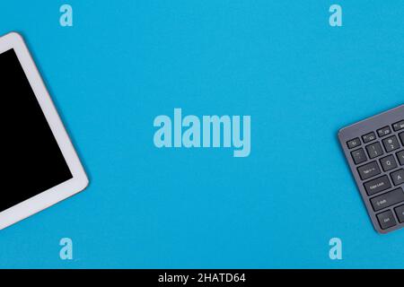 Office Workplace with Digital Gadgets Lying on Blue Table - Flat Lay Stock Photo