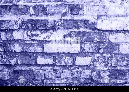 empty old brick wall texture. Shabby building facade with damaged plaster, copy space in very peri trendy color of the year 2022. background. Color of Stock Photo
