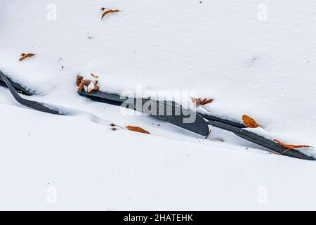 Frozen car windshield and wipers covered with ice and snow on a winter day. Close-up view. Stock Photo