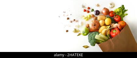 Background with recyclable brown paper shopping bag with fruits and vegetables on white table. Top view. Horizontal composition. Stock Photo