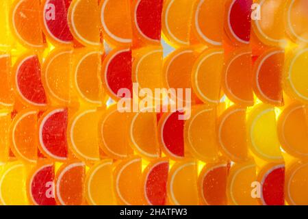 Dessert marmalade in the form of lemon and orange slices in the showcase of candy store. Blurred image sweet fruit lemon marmalade - food background. Stock Photo