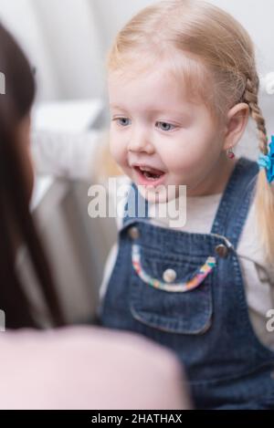 Woman speech therapist helps little girl to correct her speech in her office Stock Photo