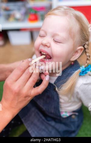 Woman speech therapist helps little girl to correct her speech in her office Stock Photo