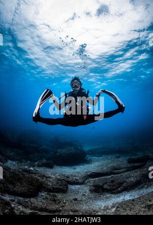 Scuba Diver doing splits underwater Stock Photo