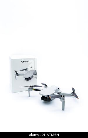 Valencia, Spain - December 13, 2021: 249 gr DJI Mini 2 drone with its box on white background. Vertical product photography with copyspace Stock Photo