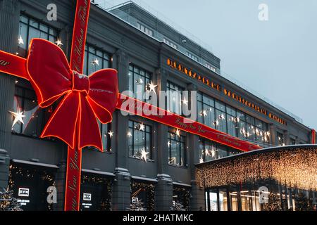 The building is decorated with a festive red bow. TSUM Department Store in Moscow. Festive evening city. New Year and Christmas decorations in the cit Stock Photo
