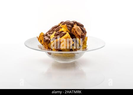 Panettone cake in pieces with chocolate cream. Italian dessert for Christmas in glass dish on white background Stock Photo