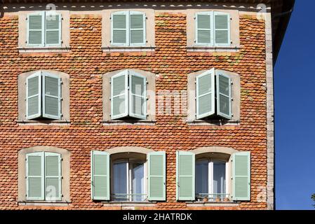 Historic Facade Covered in Overlapping Wall Tiles or Tile Shingles, Window Pattern & Pale Blue Shutters, Carces Var Provence France Stock Photo