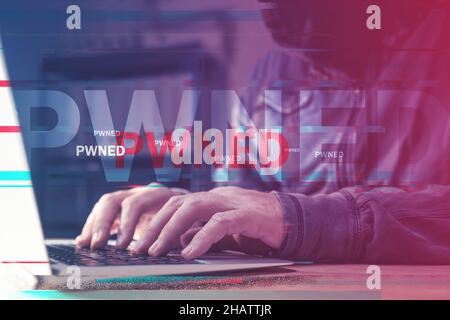 Pwned computer, hacker using laptop to get power over devices connected to a network, digitally enhanced image with selective focus Stock Photo