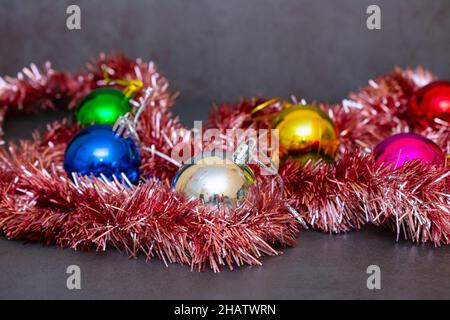 Small set of bright Christmas decorations tinsel and multicolored glass balls Stock Photo