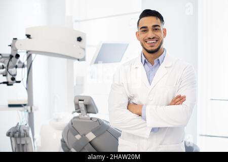 Dental Center. Portrait Of Smiling Middle Eastern Dentist Doctor Posing At Workplace Stock Photo