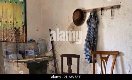 Abandoned finca as a workroom with chairs and wardrobe, hat and shirt on coat hooks, Lost Place, Andalusia, Spain Stock Photo