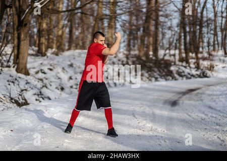 Strong muscular fighter sparring in nature at snowy winter day. Boxing, winter fitness Stock Photo