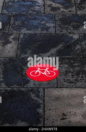 Red cycle path marking on wet pavement, Ribeira Grande, Sao Miguel Island, Azores, Portugal Stock Photo