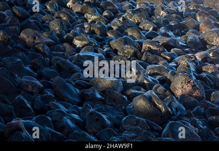 Large black lava stones on the beach of Praia de Santa Barbara, Ribeira Grande, Sao Miguel Island, Azores, Portugal Stock Photo