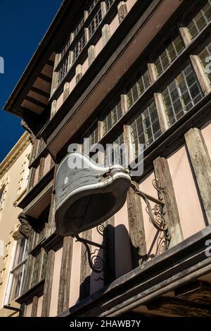 UK, England, Gloucestershire, Tewkesbury, Church Street, historic Heritage and Visitor Centre hat sign, in historic jettied timber framed building Stock Photo