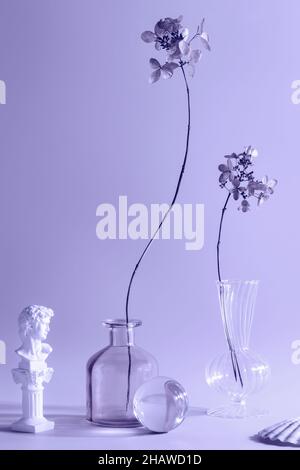 simplicity, naturalness, wabi sabi concept. dry flowers in vases toned in trendy Very Peri. color of the year. fashionable colored glass objects. Stock Photo
