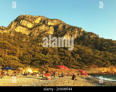 Mugla, Turkey - September 6, 2021: A mountain and Kabak beach in Fethiye Mugla Turkey. People are camping, sunbathing. Editorial shot in Fethiye Mugla Stock Photo