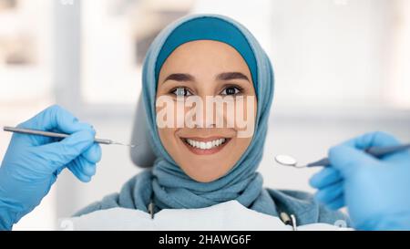Cosmetic Dentistry. Smiling Islamic Lady In Hijab Posing During Checkup In Clinic Stock Photo