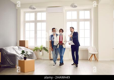 Male real estate agent shows apartment for sale to young African-American family. Stock Photo