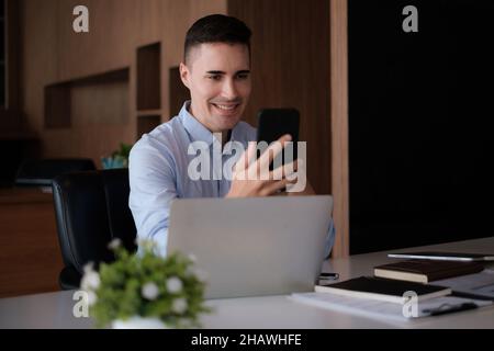 Business employee talking with speaker phone and video call by smartphone in home office. Business financial concept. Stock Photo