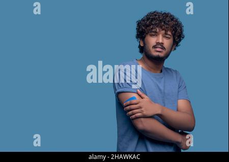 Sad man with a plaster on his arm looking ahead Stock Photo