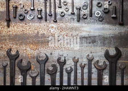 Old work tools and screws on rusty metal table. Top view variation of vintage wrenches and dirty bolt and nut fastener. Flat lay with copy space Stock Photo