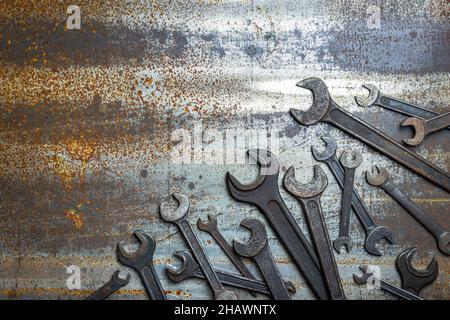 Variation of old wrench on rusty metal background, flat lay with copy space. Old spanner. Industrial tool Stock Photo