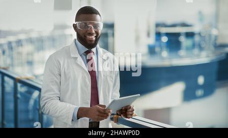 Happy young black medical scientist using digital tablet Stock Photo