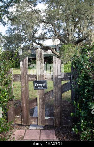 Black direntional wedding ceremony sign hanging from charming wood fence Stock Photo