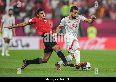 Doha, Qatar. 15th Dec, 2021. Egypt's Osama Faisal (L) and Tunisia's Naim Sliti battle for the ball during the FIFA Arab Cup semifinal soccer match between Tunisia and Egypt at Stadium 974. Credit: Ayman Aref/dpa/Alamy Live News Stock Photo