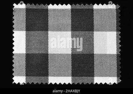 Black and white checkered fabric sample isolated on black background Stock Photo